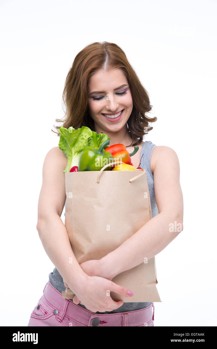 Happy woman holding a shopping bag full of groceries and looking on it Stock Photo