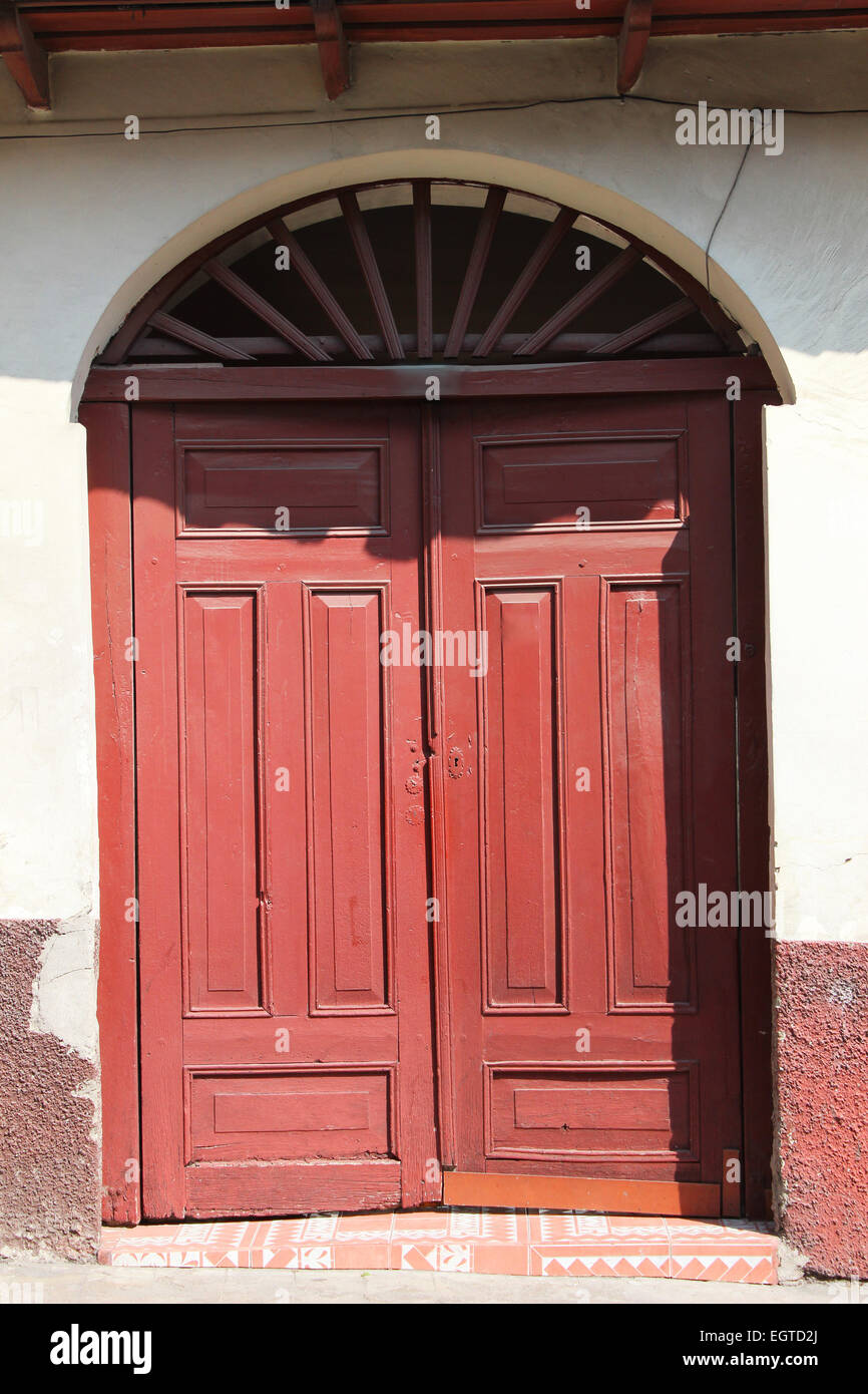 A wooden door in a wall in a building in Cotacachi, Ecuador Stock Photo