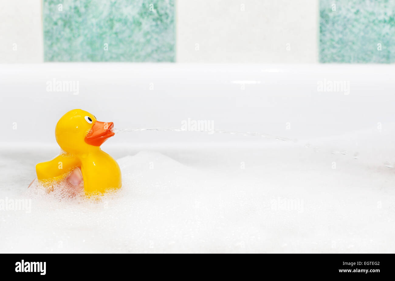 Cute rubber duck floating in suds isolated with copy space Stock Photo