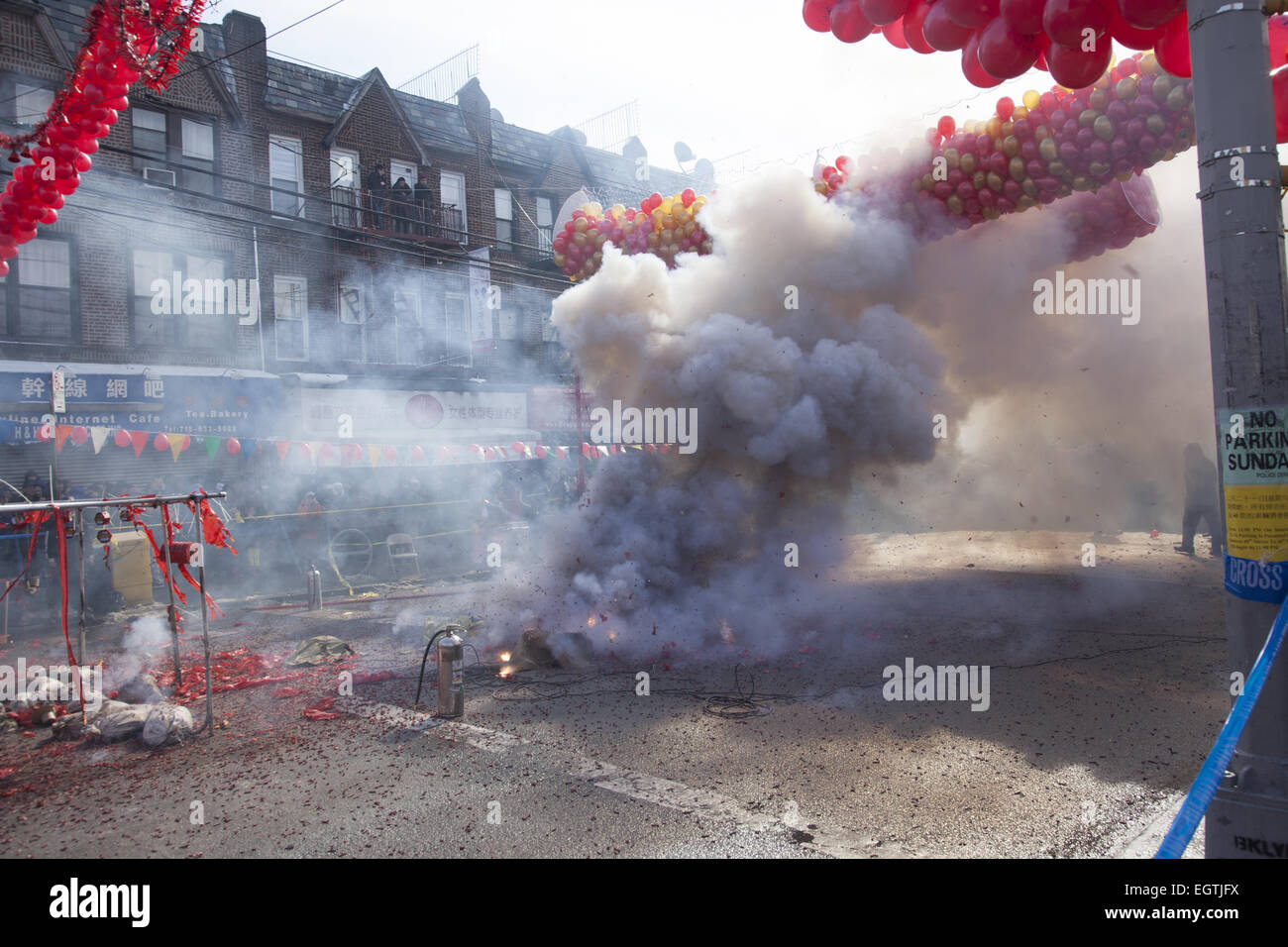 Street becomes enveloped in smoke during the firecracker ceremony on Chinese New Year in the Chinatown section of Brooklyn, NY. Chinese people from the Chinatown/Sunset Park neighborhood of Brooklyn, NY celebrate Chinese New Year  with a parade and festival bringing in The Year Of The Ram, 2015 Stock Photo