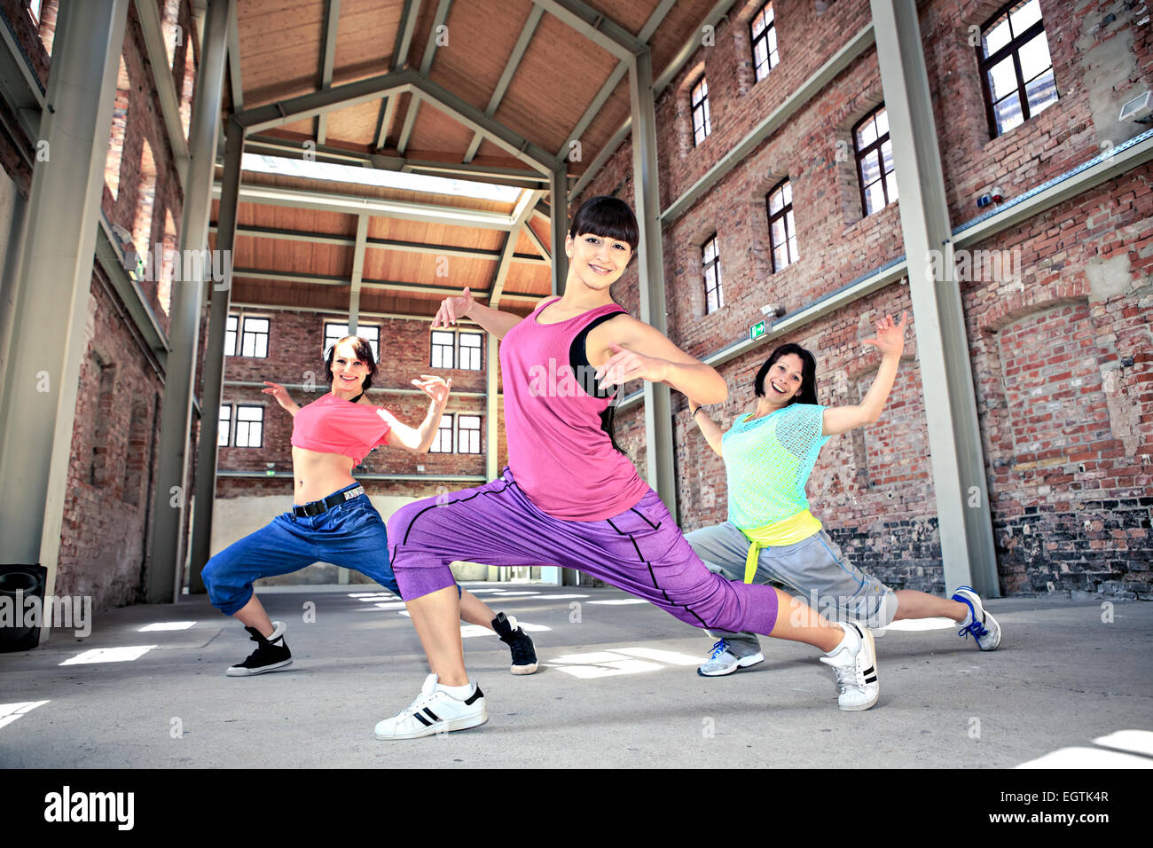 group of  women in sport dress dancing a fitness dance or aerobics Stock Photo