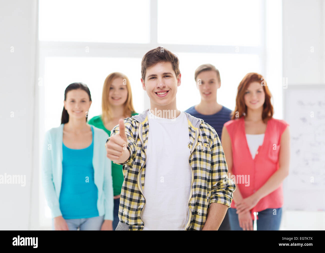 male student with classmates showing thumbs up Stock Photo - Alamy