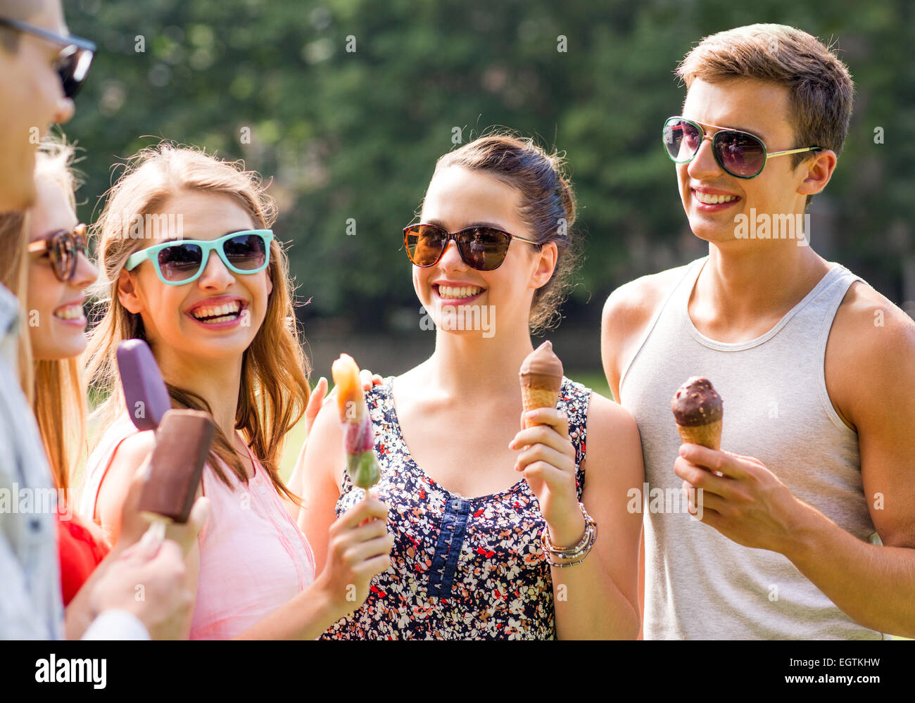 group of smiling friends with ice cream outdoors Stock Photo