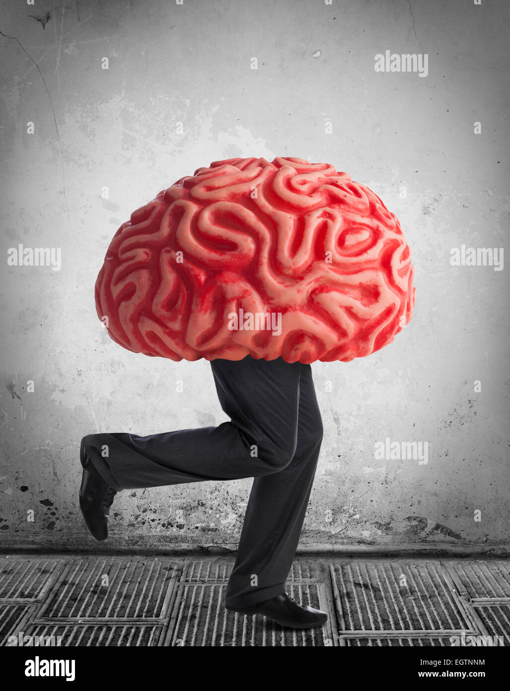 Metaphor of the brain drain. Rubber brain legs while running. Stock Photo