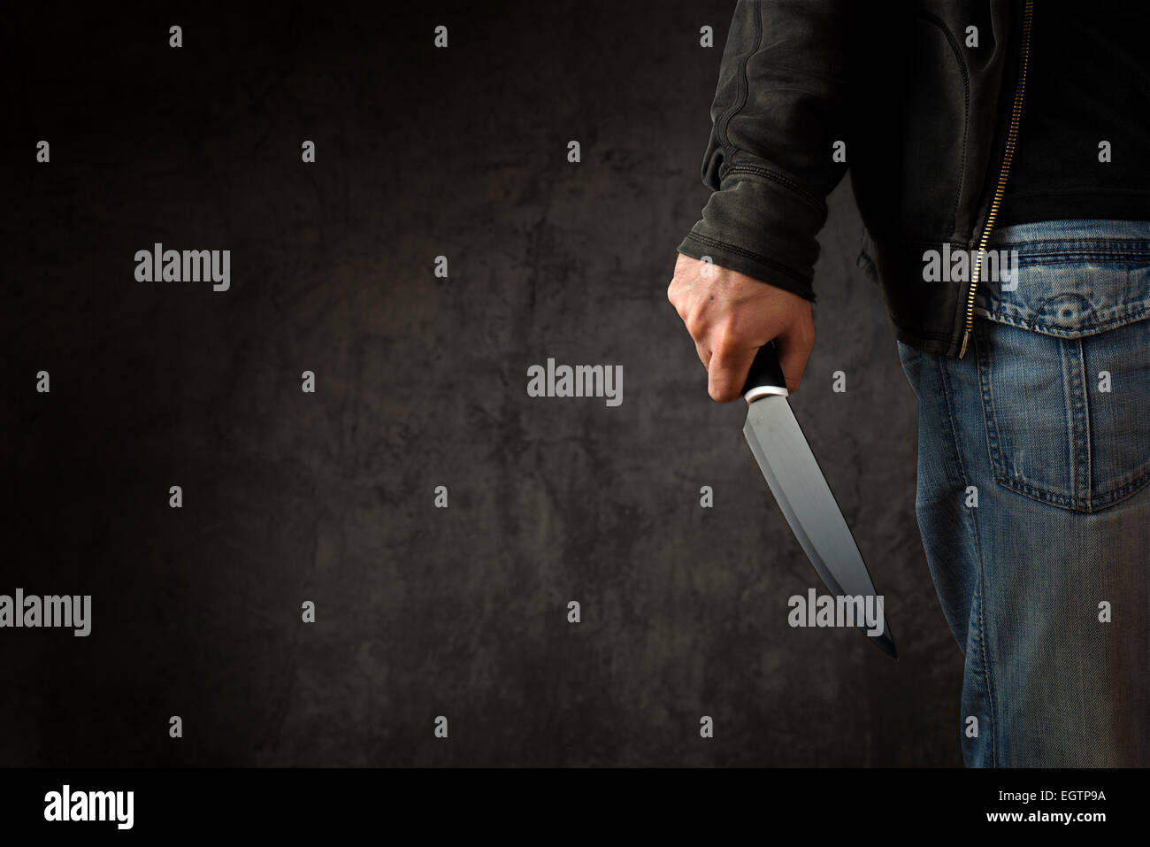 Evil criminal with large sharp knife ready for robbery or to commit a homicide Stock Photo