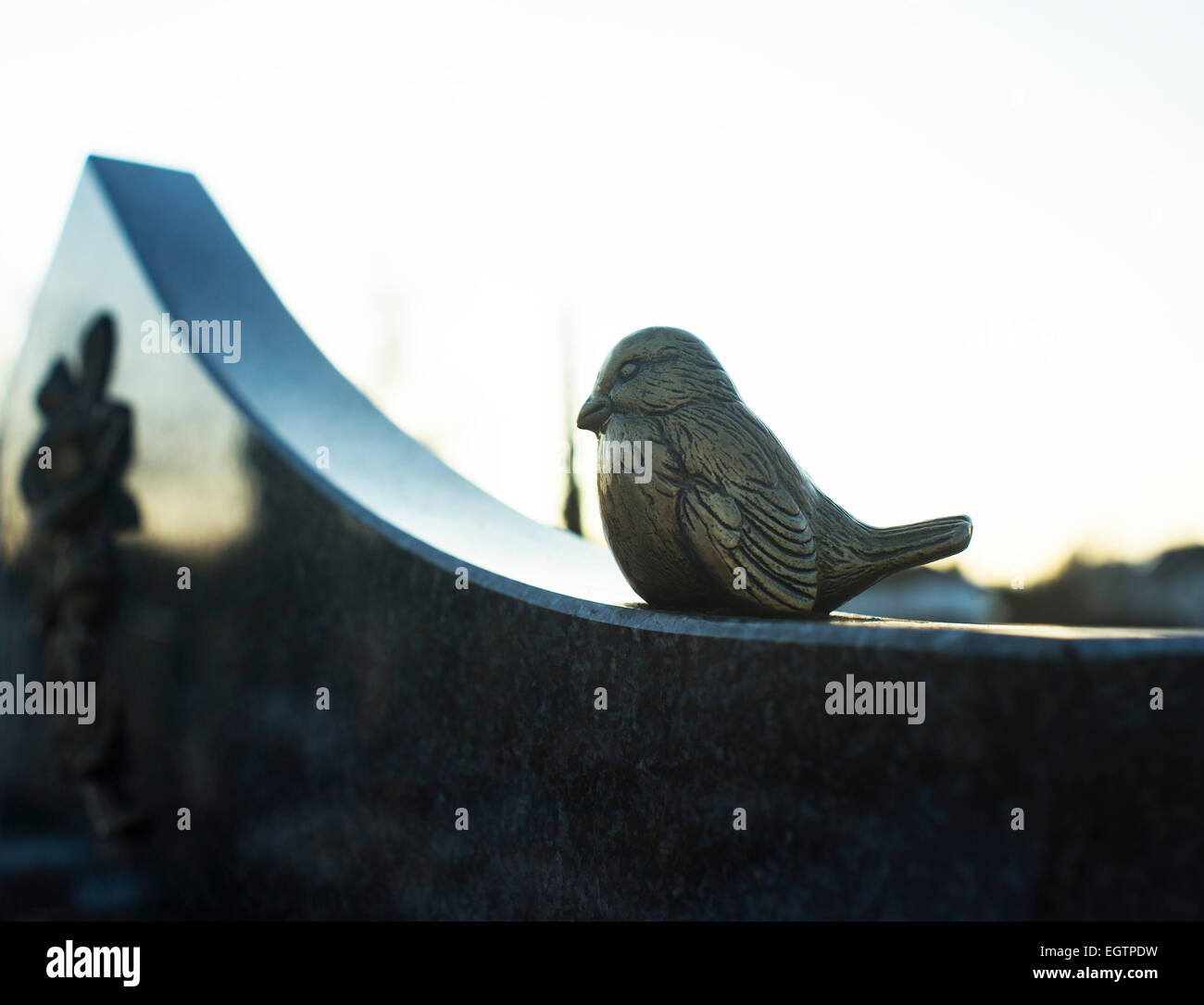 Sculpture bird, sitting on a gravestone. Stock Photo