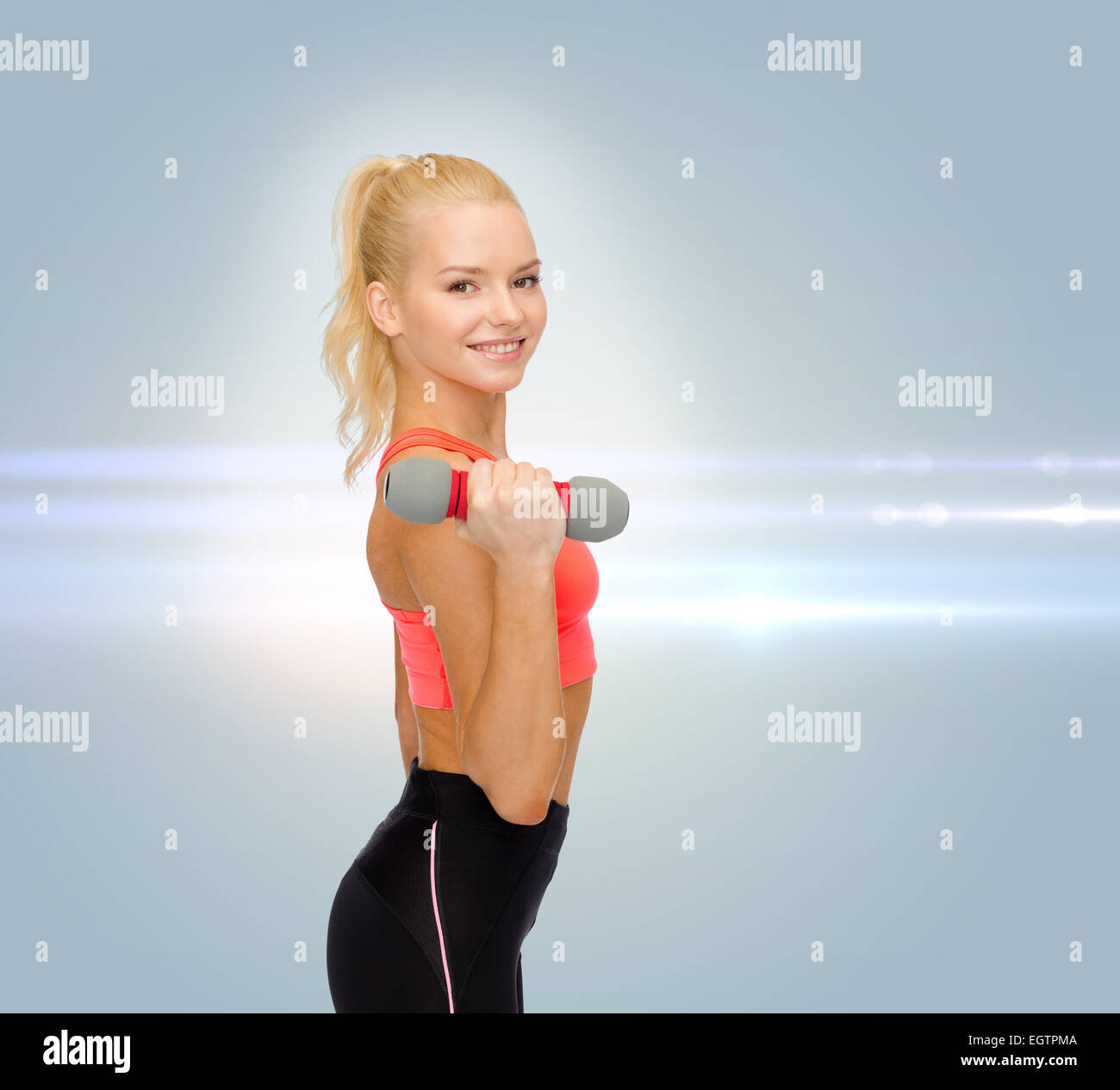 smiling beautiful sporty woman with dumbbell Stock Photo