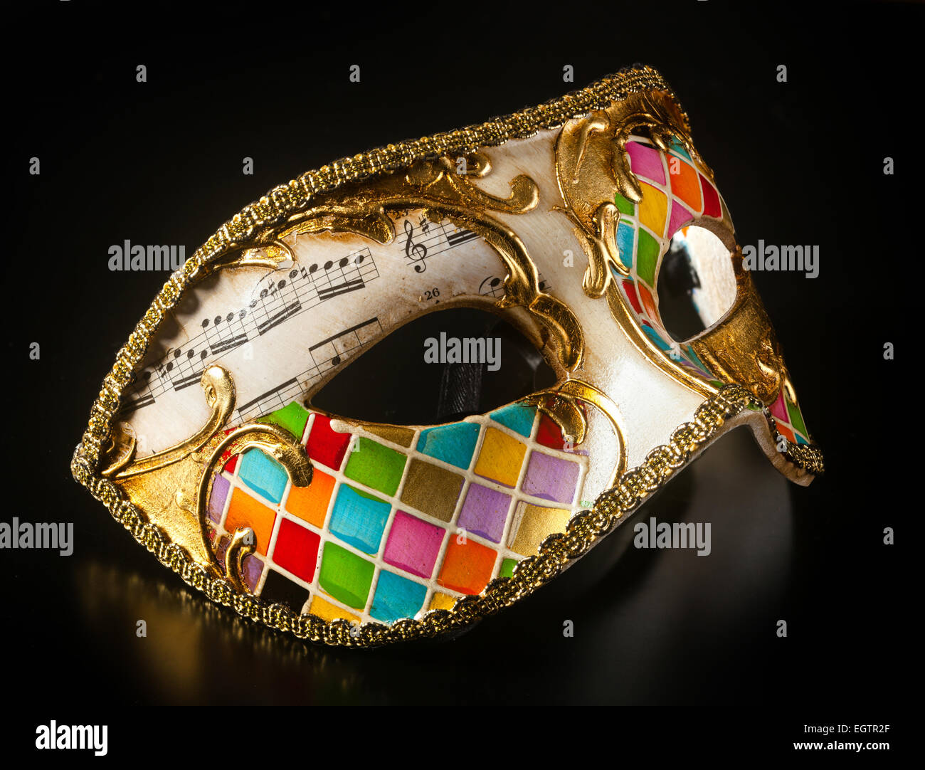 Venetian mask harlequin style isolated on black background. Stock Photo