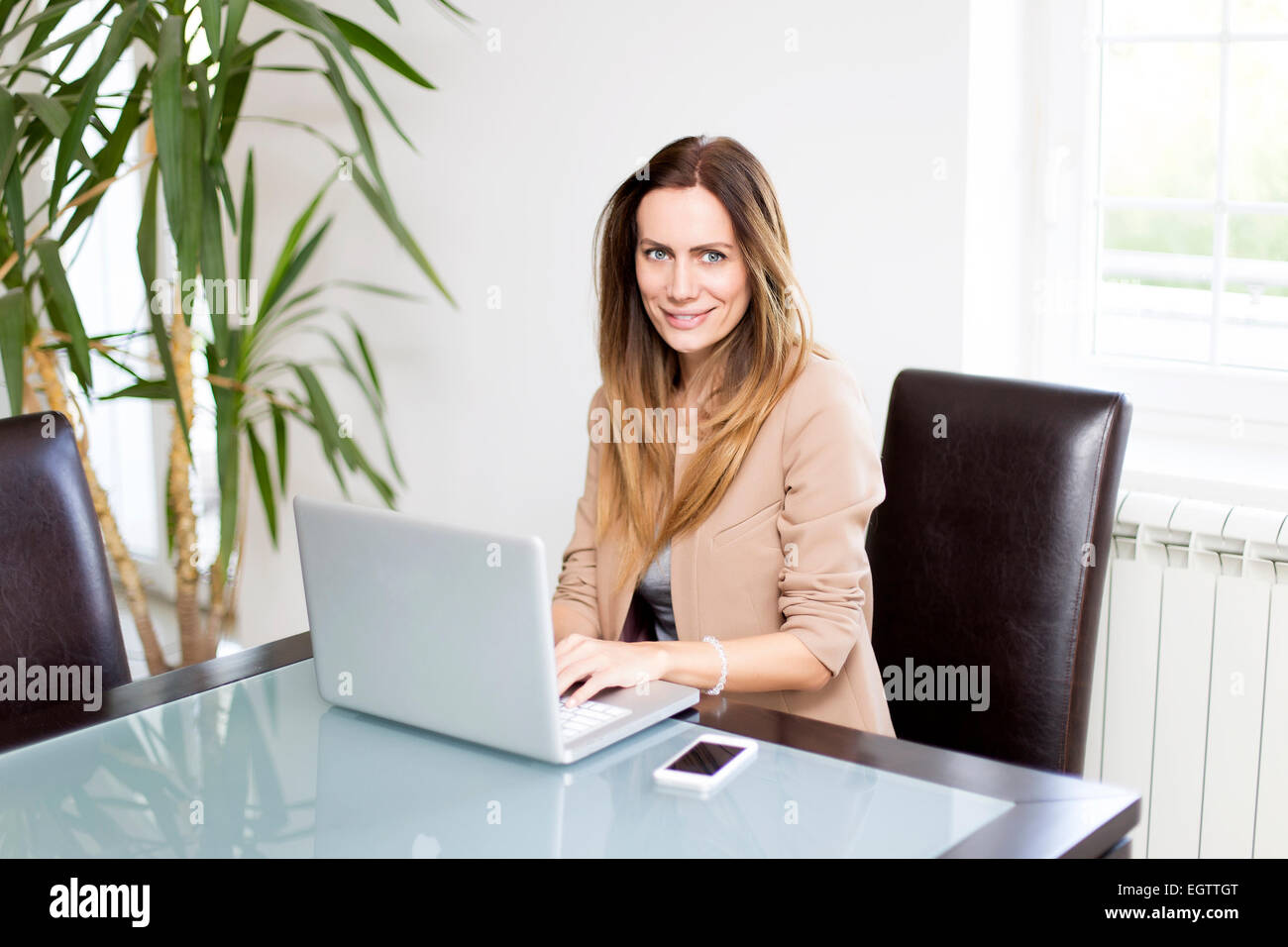 Young woman working on laptop in the room Stock Photo - Alamy
