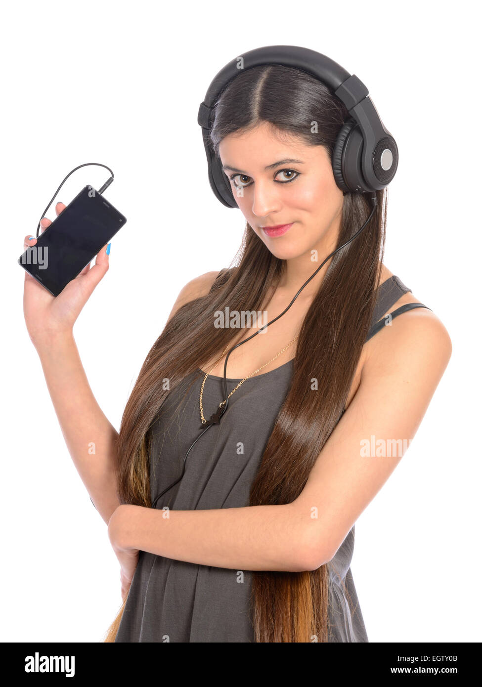 young woman with large headphones listening to music on mobile phone Stock Photo