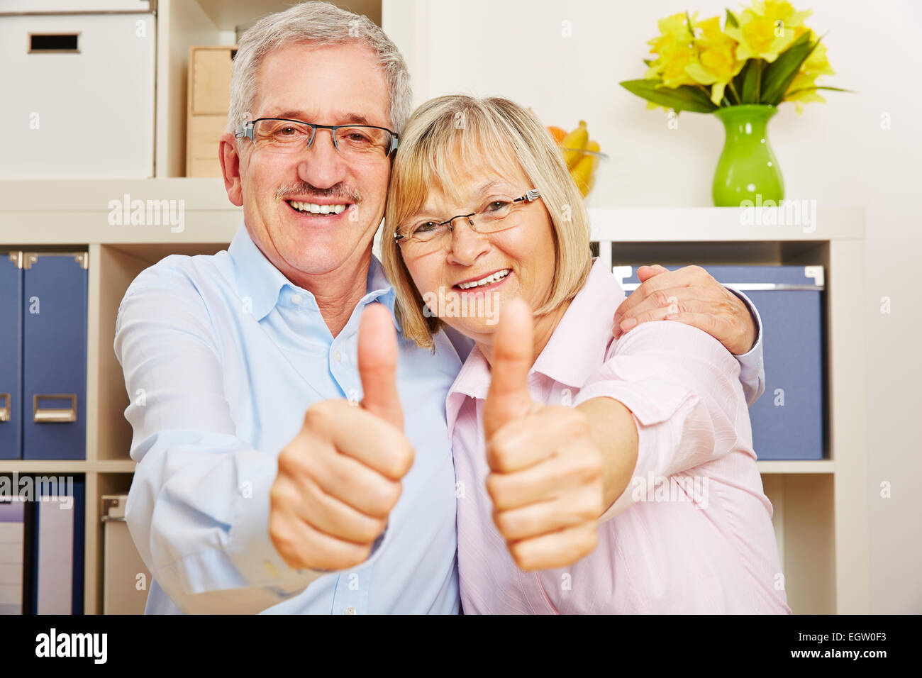 Happy couple of senior citizens holding thumbs up together Stock Photo