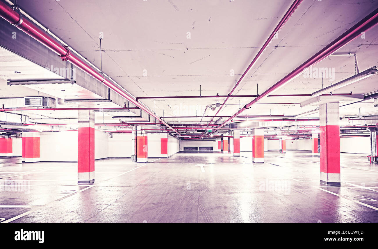 Retro filtered photo of underground parking, industrial interior. Stock Photo