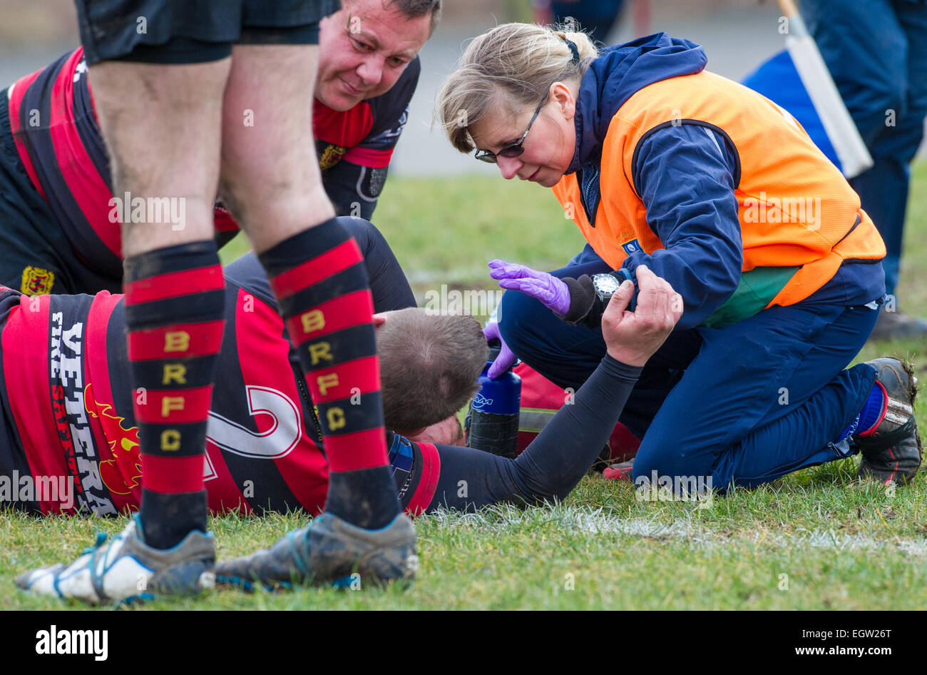 Male rugby union football player receiving treatment from a female