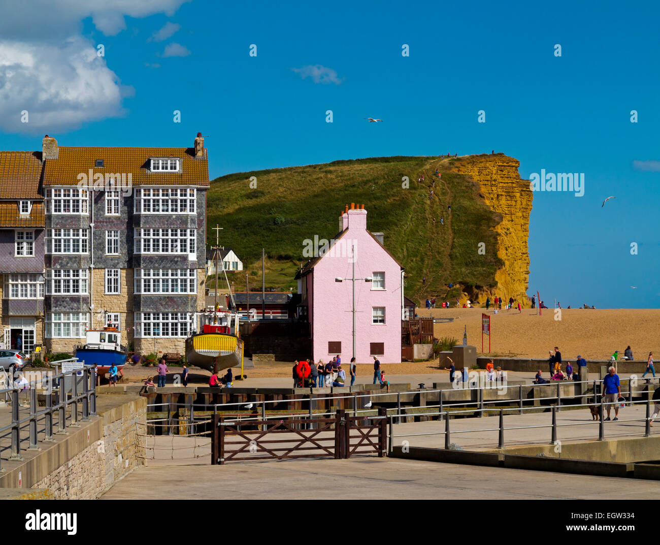 Buildings and sandstone cliffs at West Bay a small fishing port near Bridport on Jurassic Coast in Dorset south west England UK Stock Photo