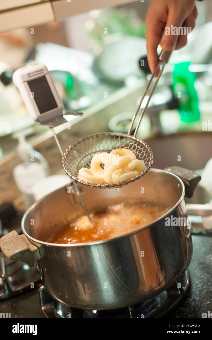 Drainging excess oil from fried squid Stock Photo Alamy