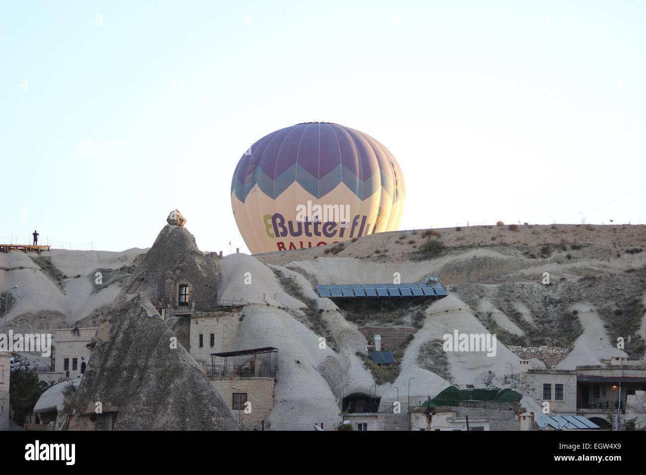 Hot air balloon rising from the valley behind the hill, Goreme, Cappadocia. Stock Photo