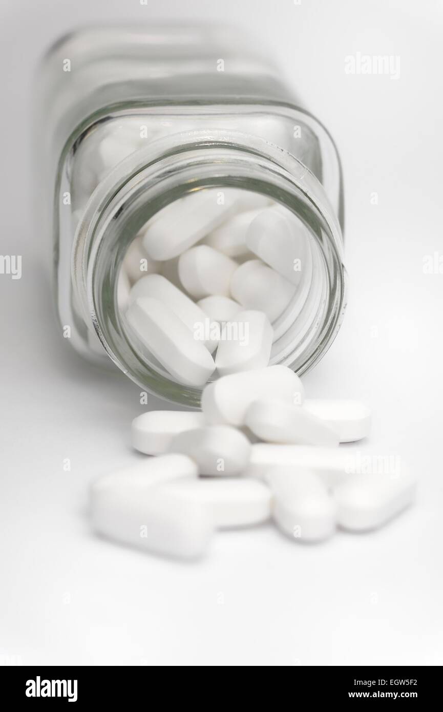 White tablets in a small glass jar close up Stock Photo Alamy