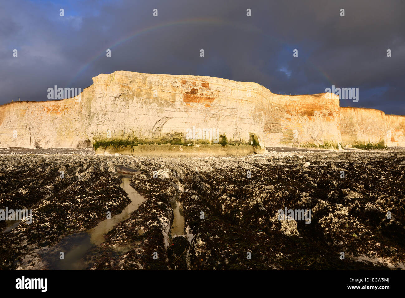 Rainbow, rockpools and chalk cliffs at Peacehaven/Telscombe Cliffs Stock Photo