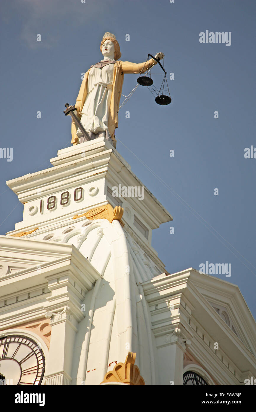 Statue of Lady Justice on top of a courthouse building on a sunny day