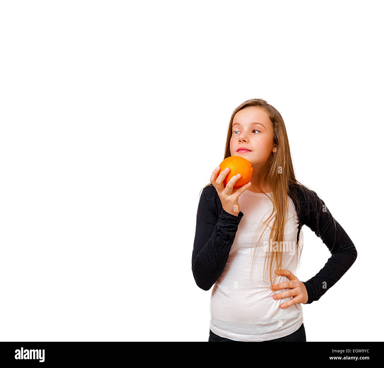 Thinking little girl with orange isolated on white Stock Photo