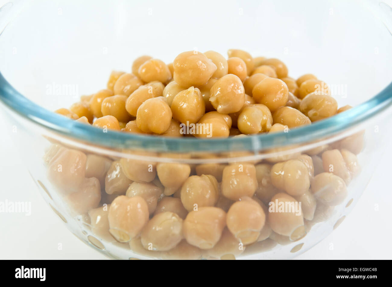 Close up of chick peas in glass bowl on white background Stock Photo