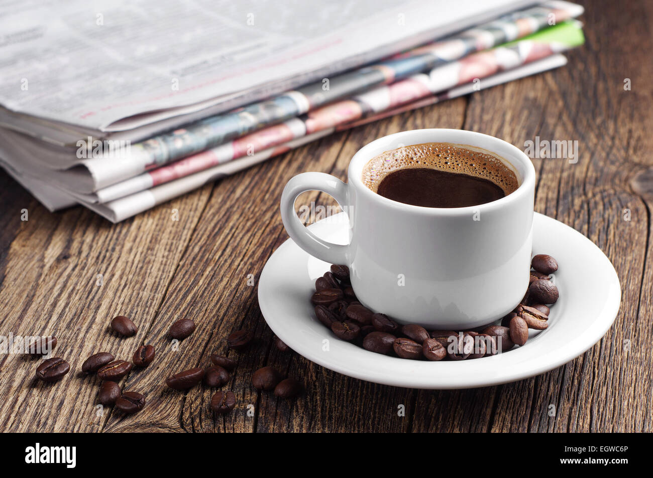 Cup of coffee and newspaper on old wooden table Stock Photo