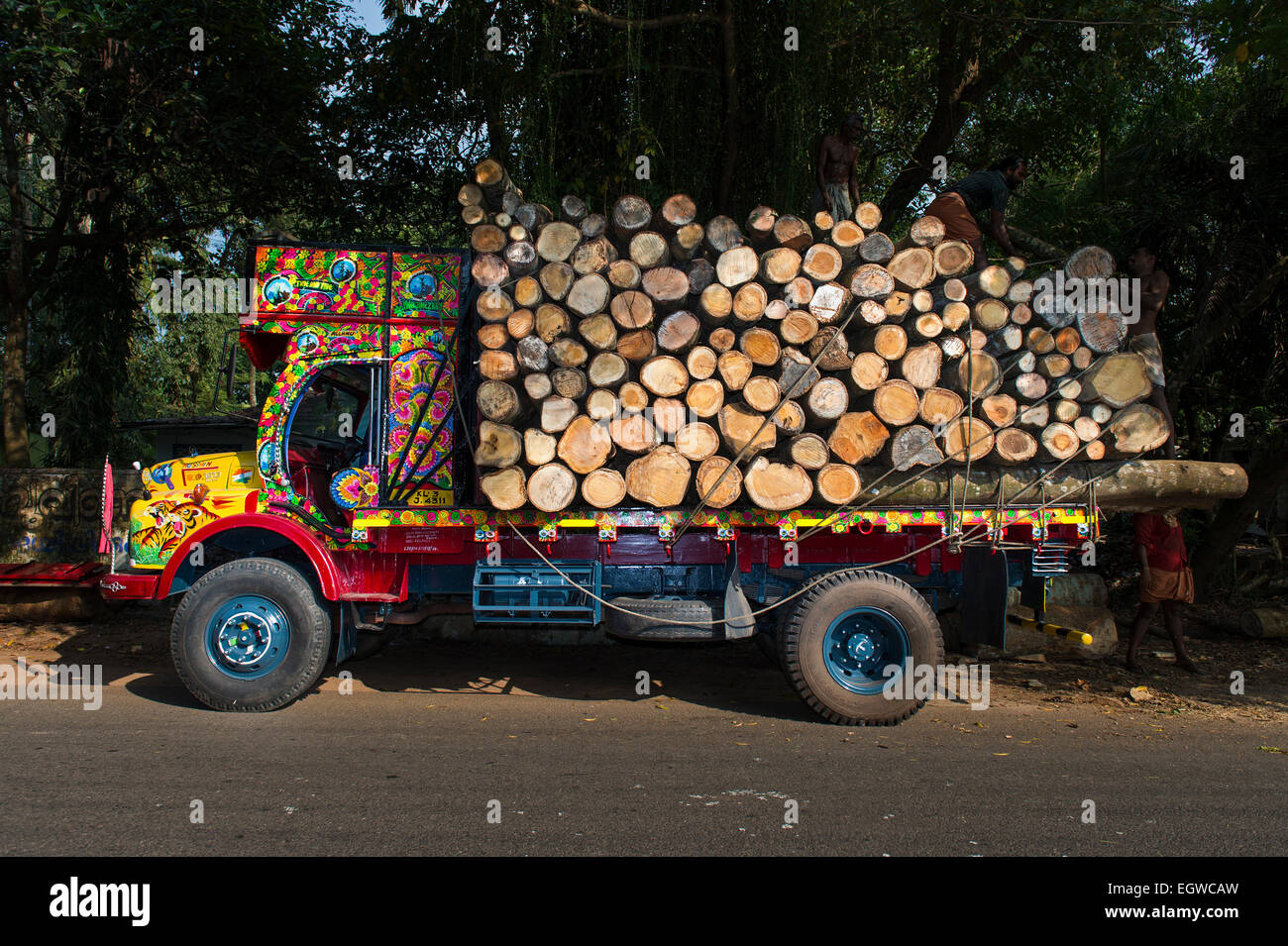 Brightly painted truck loaded with logs, near Alleppy, Kerala, India Stock Photo