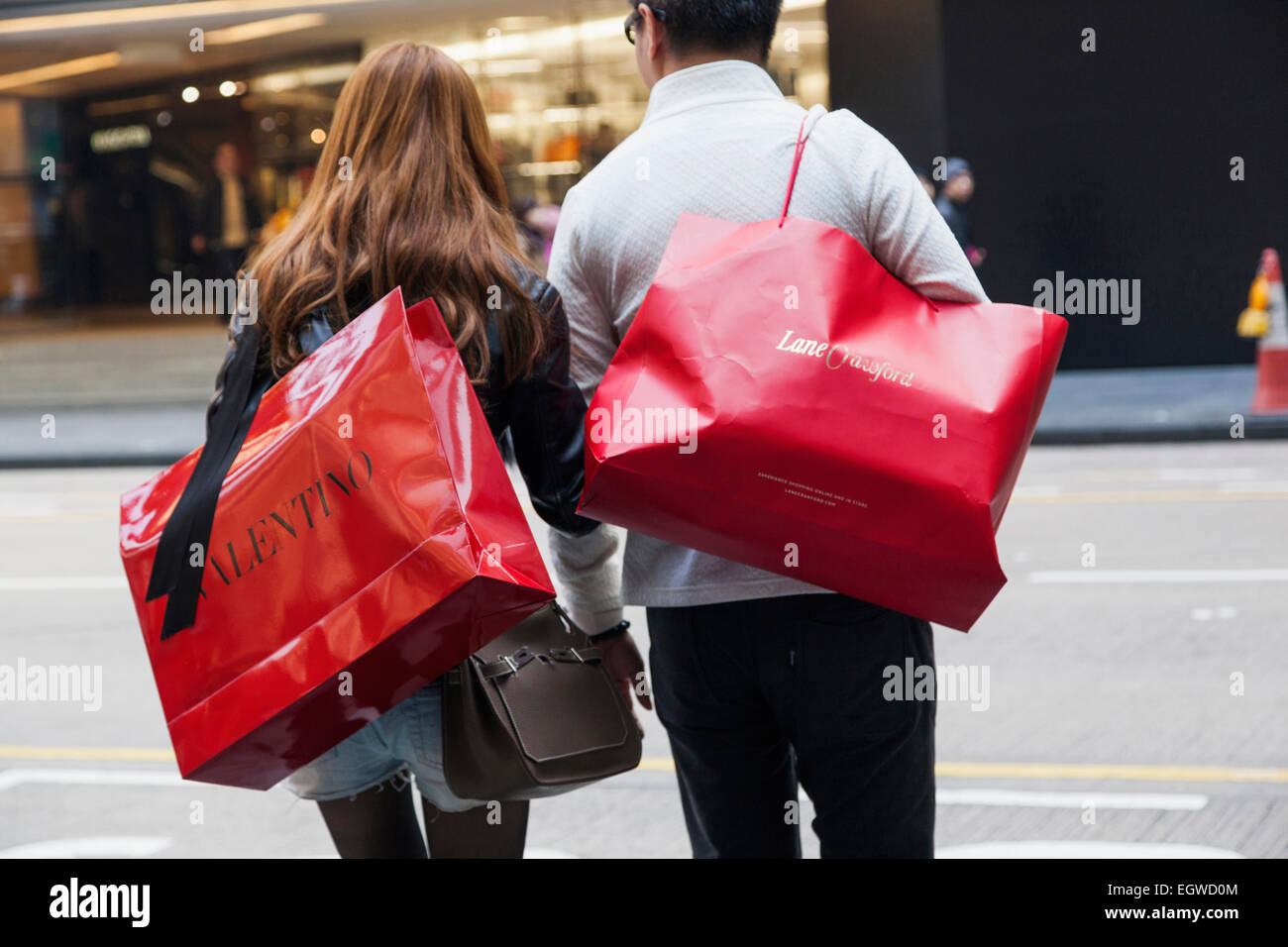 China, Hong Kong, Central, Couple Carrying Valentino and Lane Crawford Shopping Bags Stock Photo