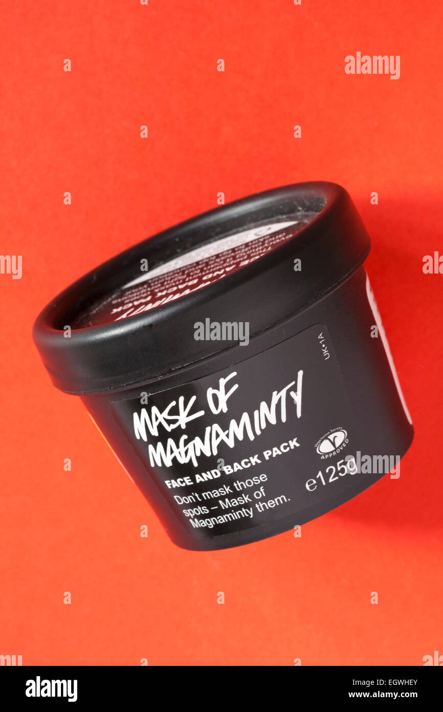 Tub of Lush mask of magnaminty face and back pack isolated on red background Stock Photo
