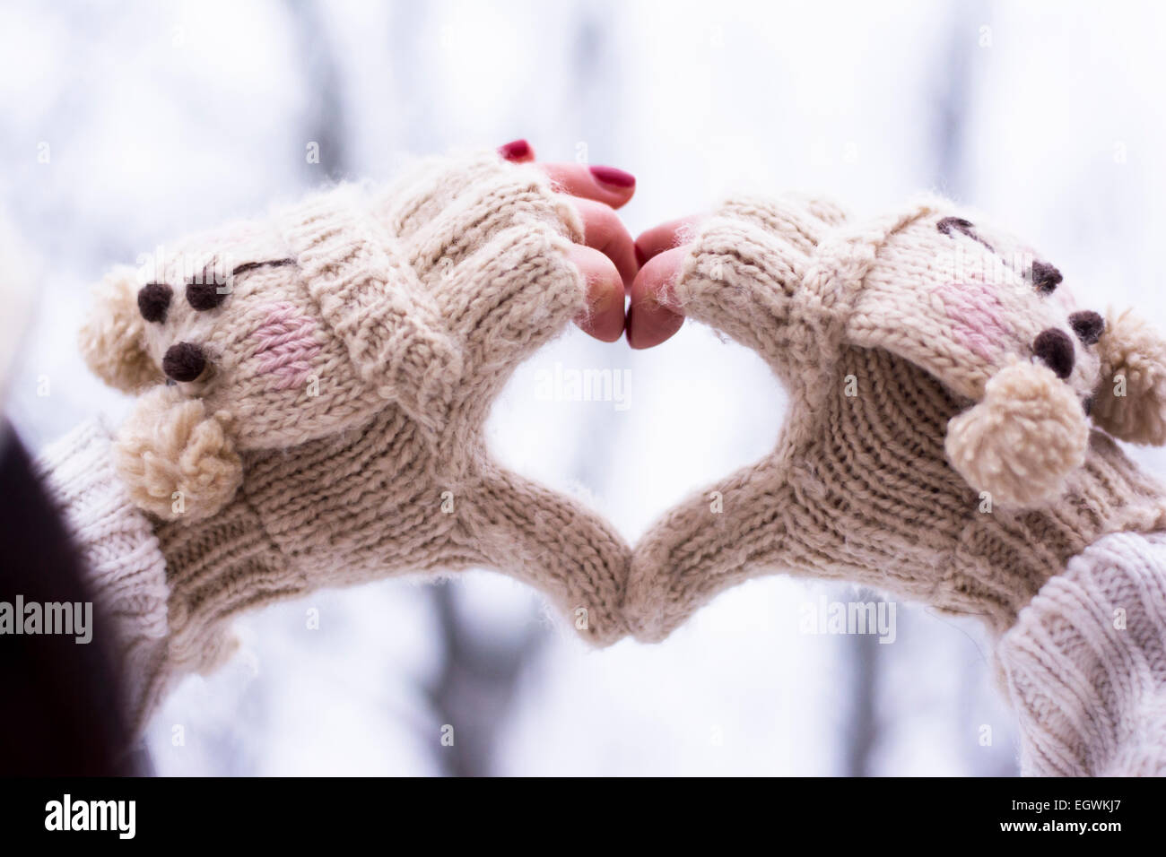 Heart shape made of hands wearing knitwear gloves outdoors Stock Photo