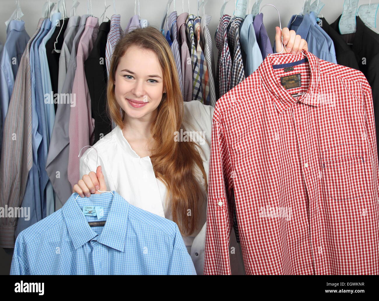 A Employee of a dry cleaning presenting two clean shirts Stock Photo