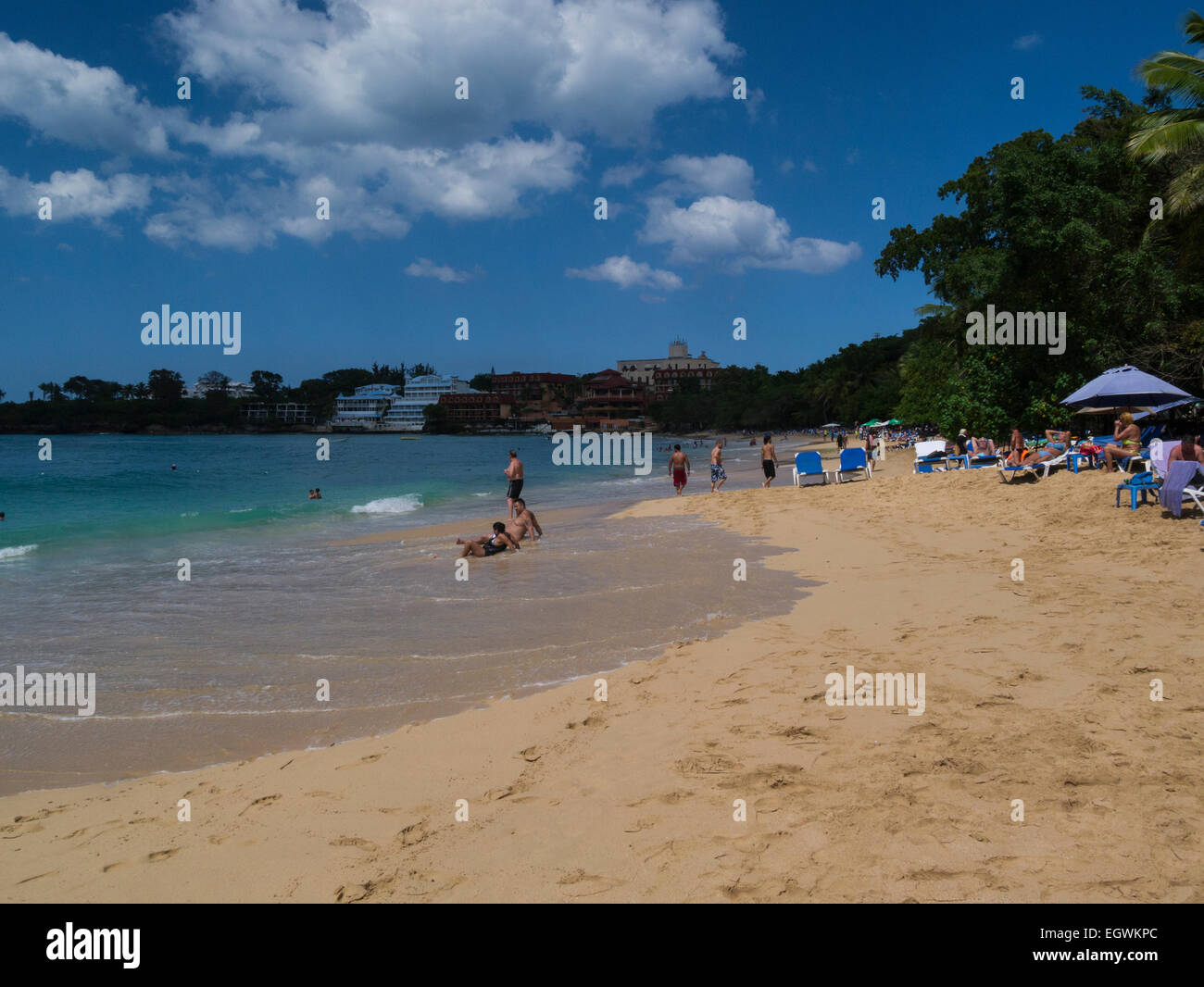 View along the popular public beach of Playa de Sosua Dominican Republic holidaymakers holidaying on lovely winters day Stock Photo