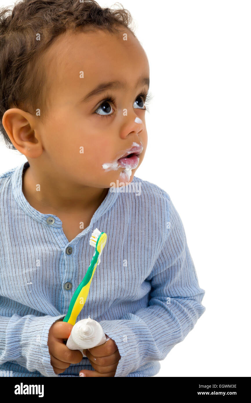 Smiling 18th month old African toddler boy brushing his teeth Stock