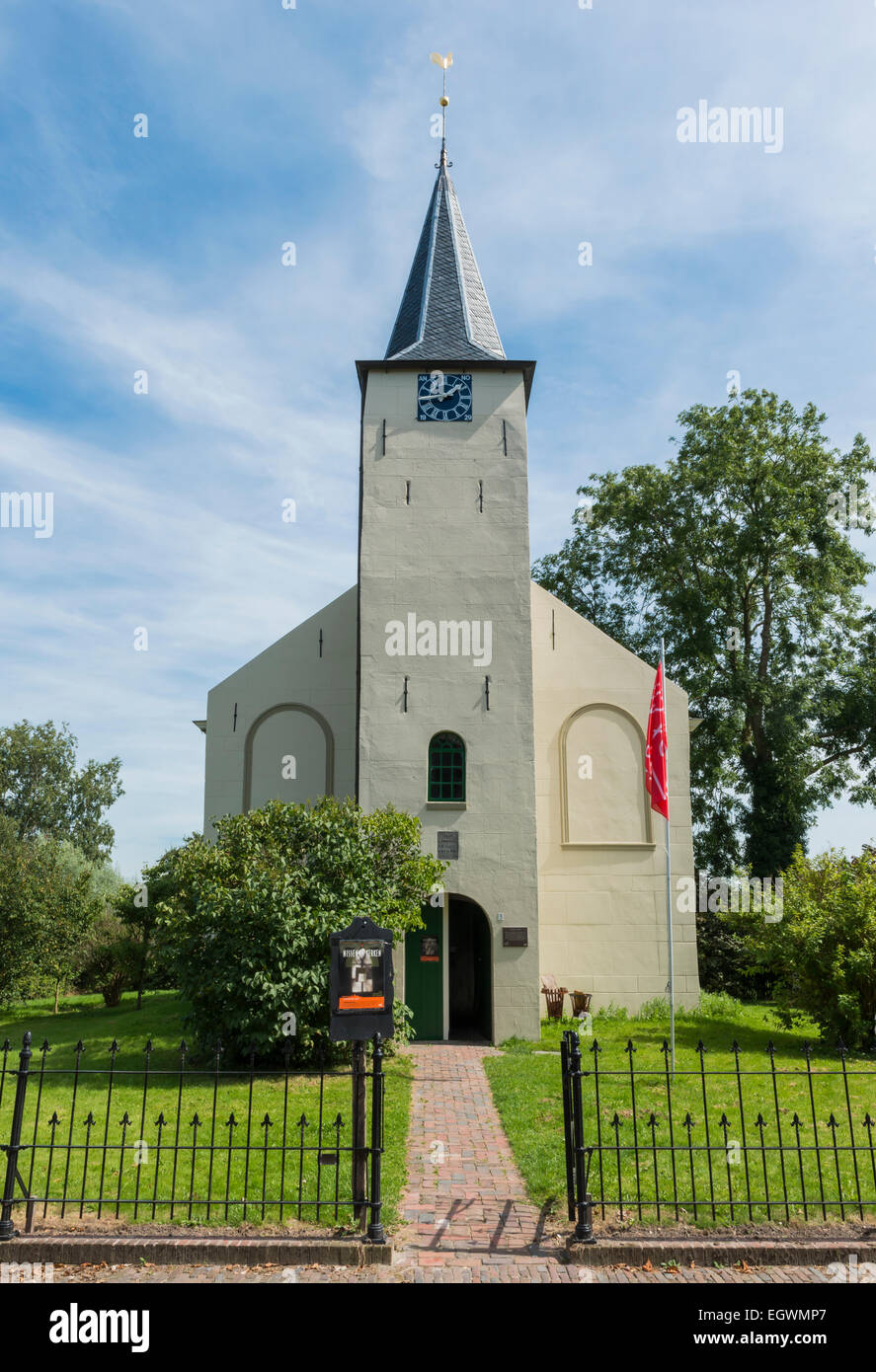 The small white church of Feerwerd with the flag of The Stichting Groninger Kerken. Stock Photo