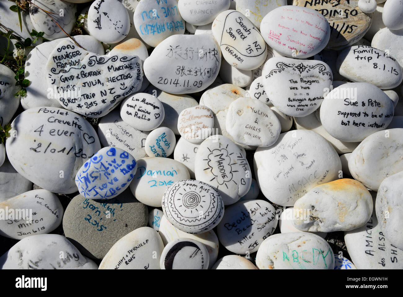 Painted stones with messages left by travellers at Ship Creek in the Tauparikākā Marine reserve, on the west coast of South Island New Zealand. Stock Photo
