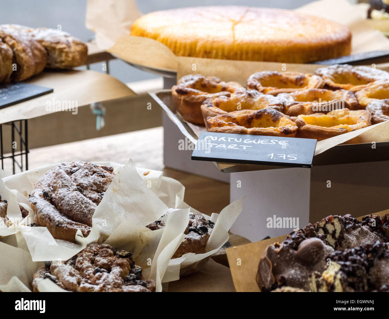 Portuguese Custard Tarts or Pastel De Nata and assorted other cakes on display at a Cambridge Cafe. Stock Photo