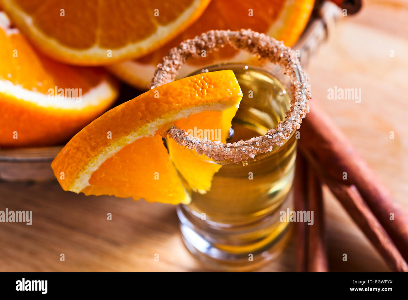 tequila with orange and cinnamon on a wooden table Stock Photo Alamy
