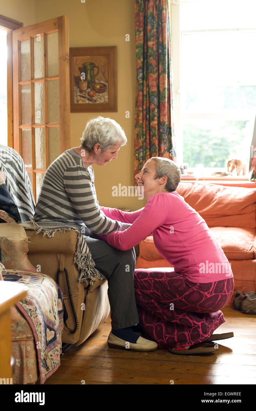 A daughter looking after her mother who is suffering from Alzeimer's. Stock Photo