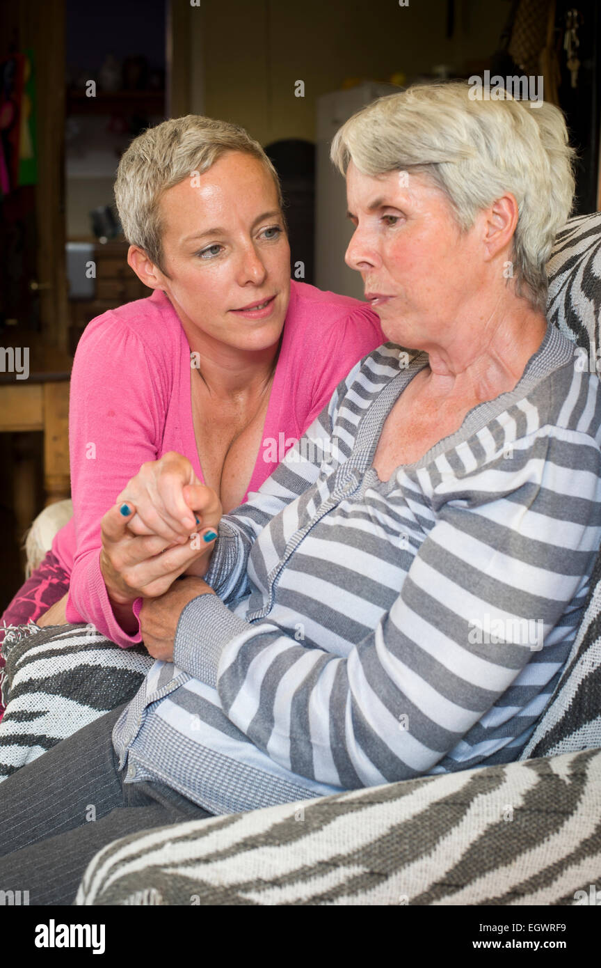 A daughter looking after her mother who is suffering from Alzeimer's. Stock Photo