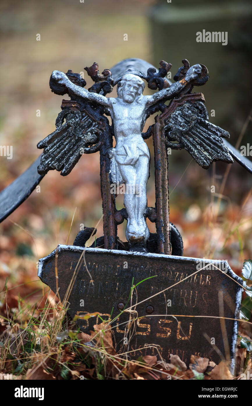 Old and broken metal cross at cemetery Color Stock Photo