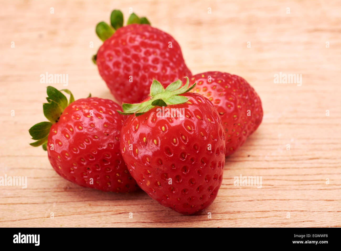 Strawberries in wood background Stock Photo - Alamy