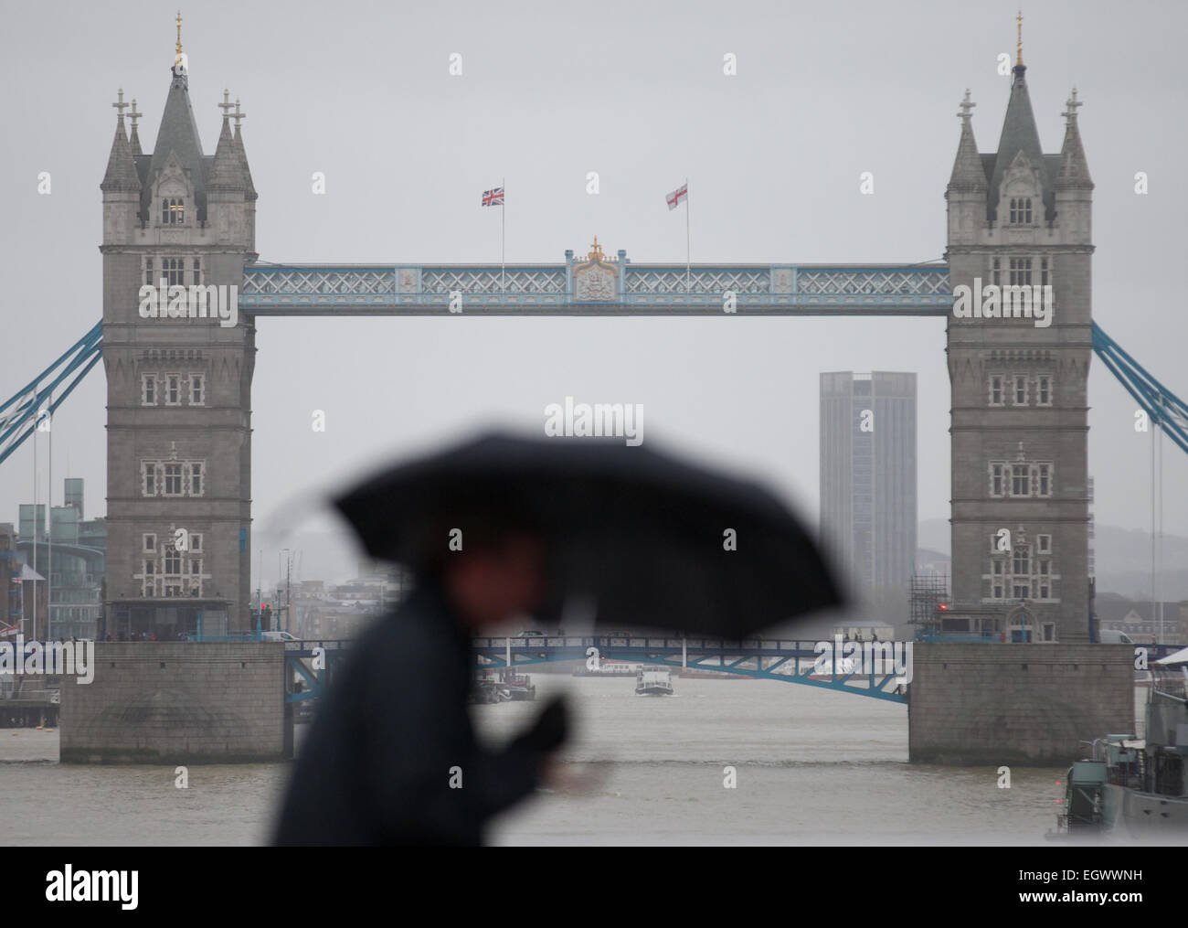 UNITED KINGDOM, London : A man battles the high winds with her umbrella as he walks across a bridge in central London on February 12, 2014. Stock Photo