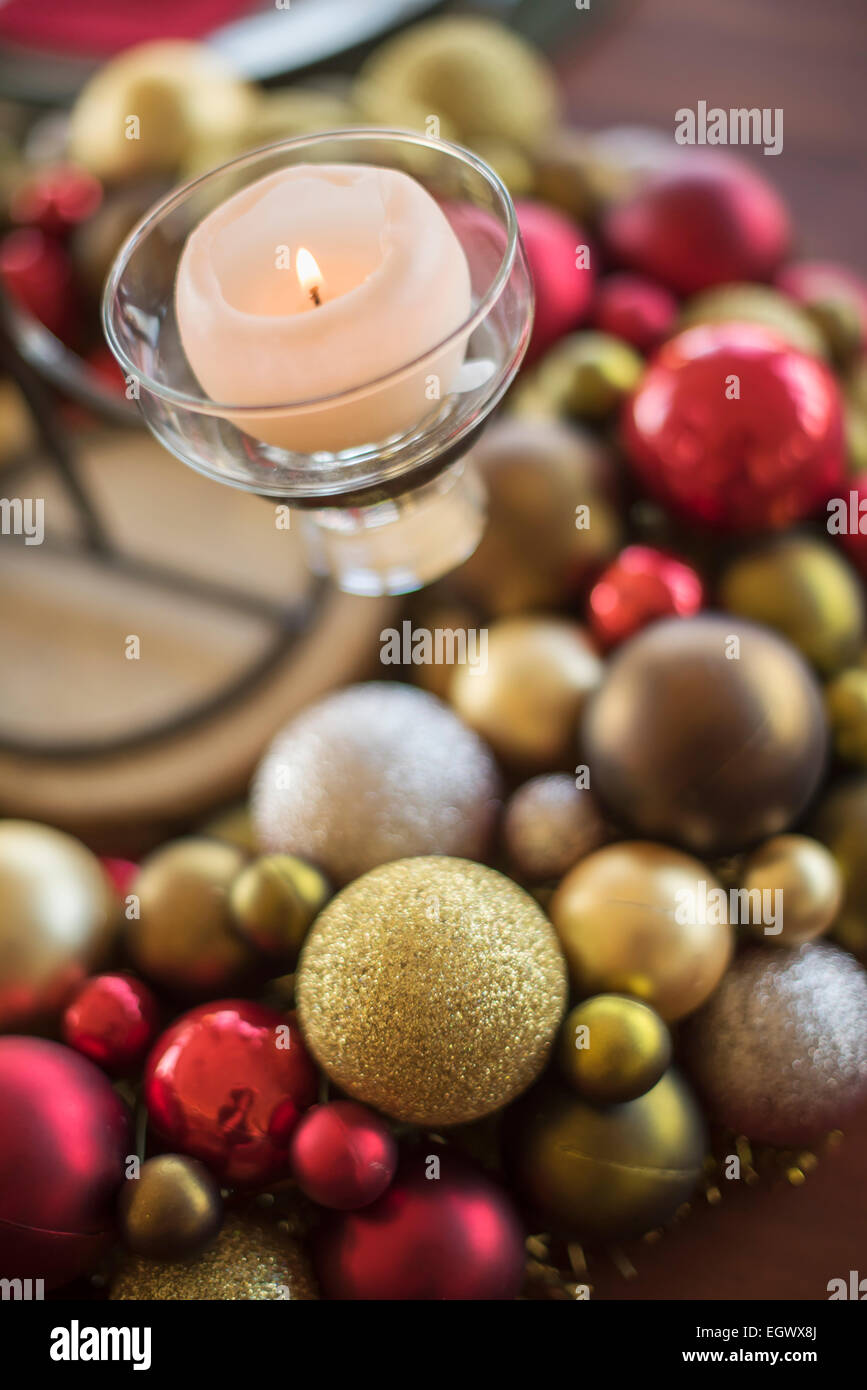 A table laid for a celebration meal. Christmas ornaments, decorations and a candle in a candle holder. Stock Photo