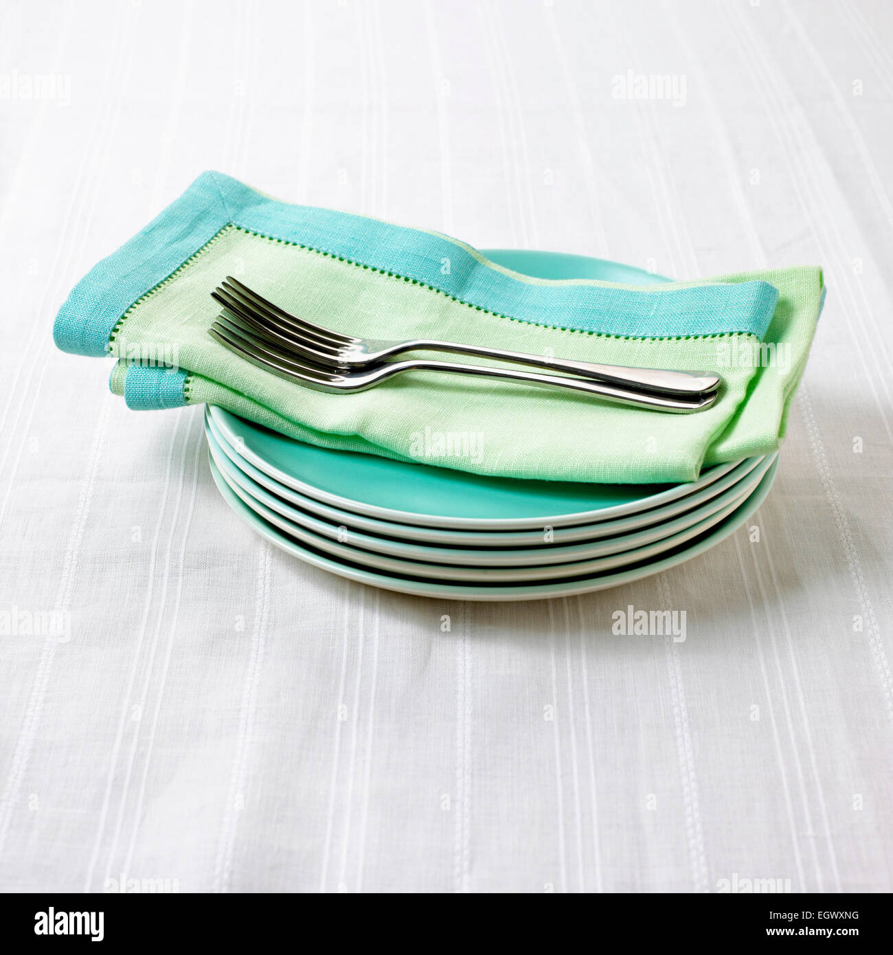 Napkin and dessert forks on stack of plates Stock Photo Alamy