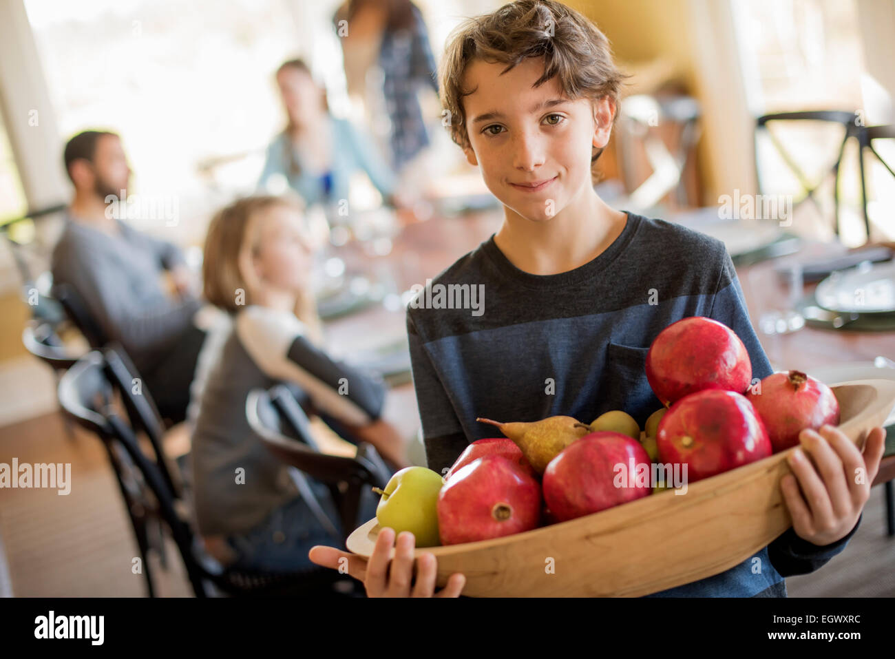 A boy carring a wooden tray of apples. Stock Photo