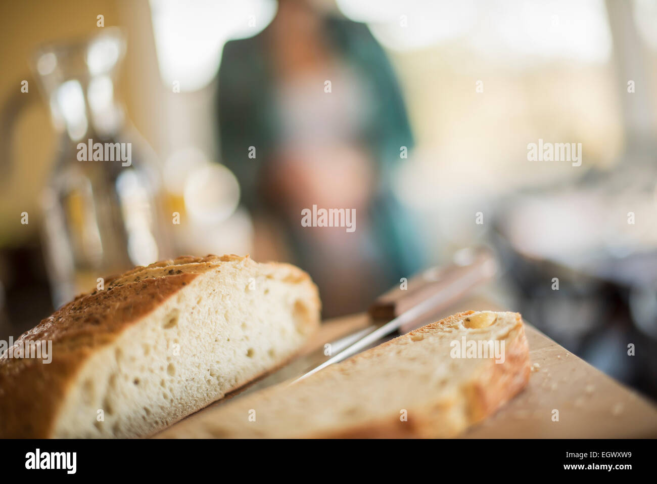 A loaf and bread knife on a bread board. Stock Photo