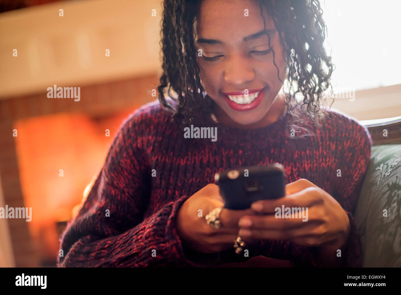 A woman checking her cell phone and smiling. Stock Photo
