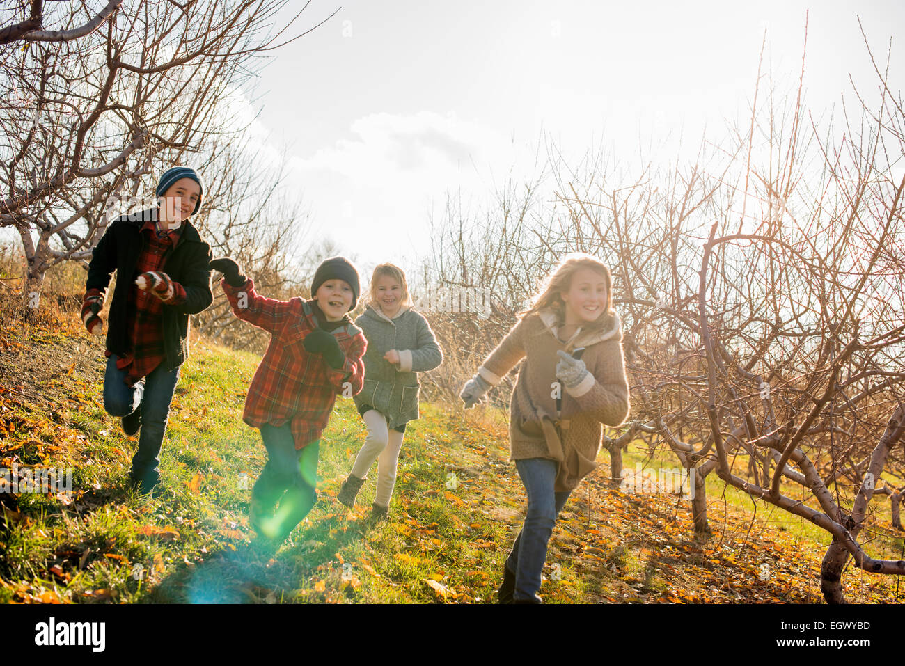 Four children running outdoors in winter Stock Photo