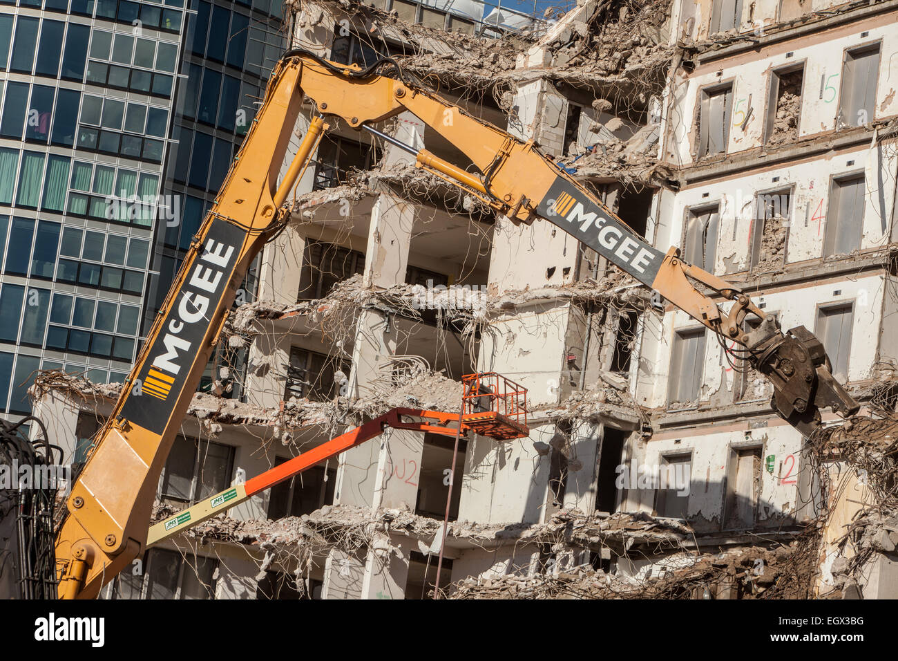 Demolition and Construction with mechanical digger in foreground Stock Photo