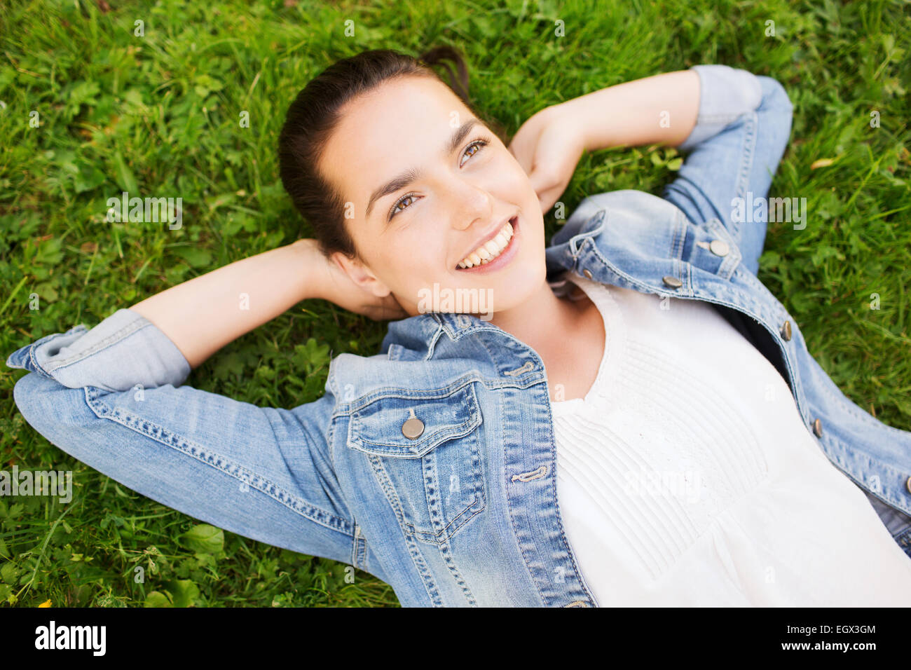 smiling young girl lying on grass Stock Photo - Alamy